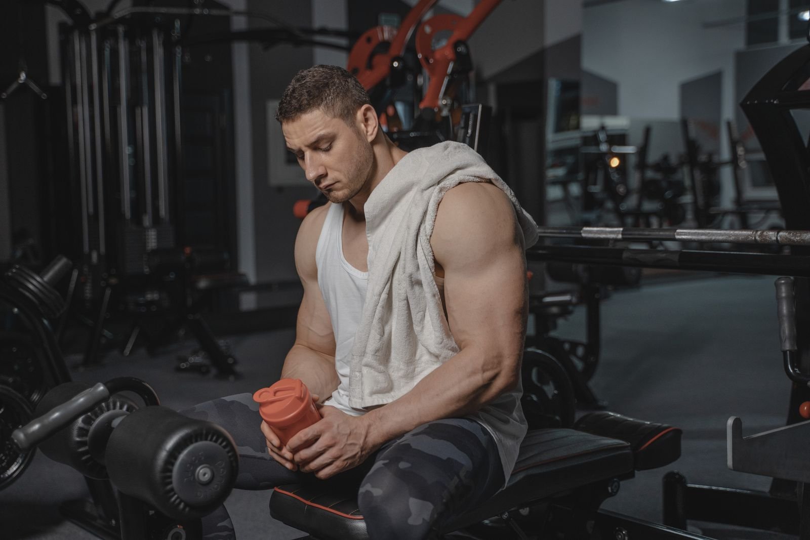 Man sitting and resting between sets in a gym