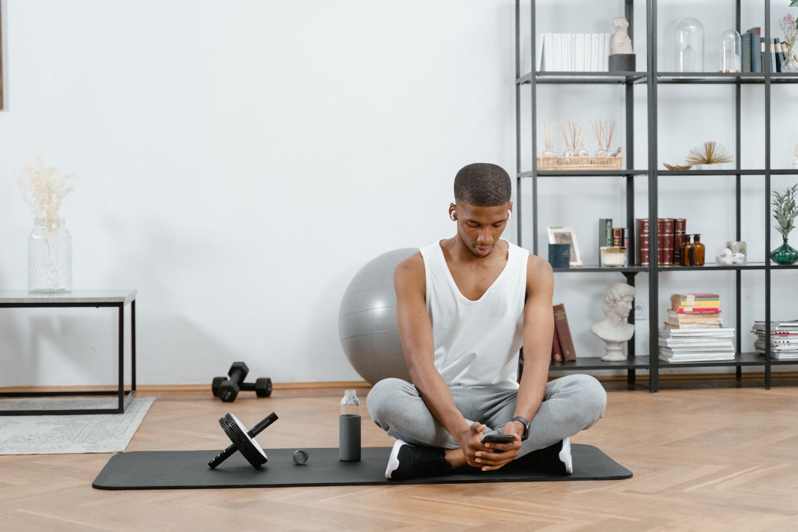 Man sitting on a yoga mat at home after a workout