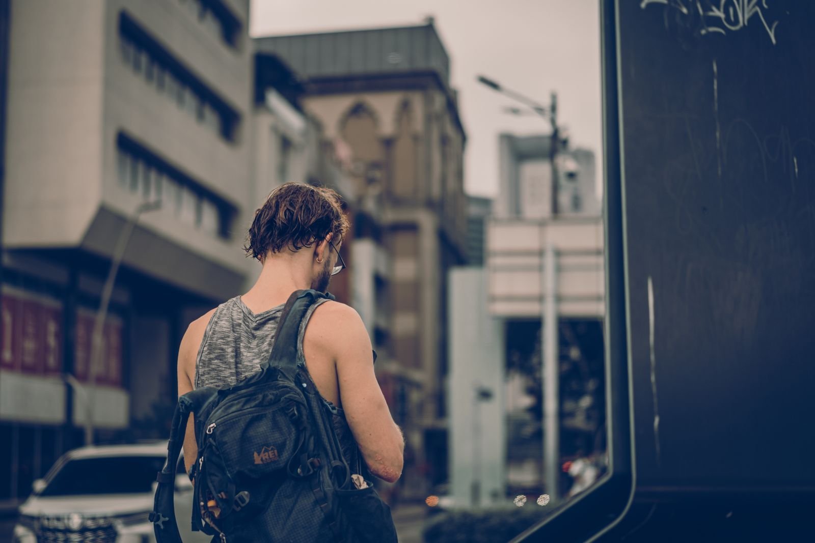 Man with a backpack walking down a city street