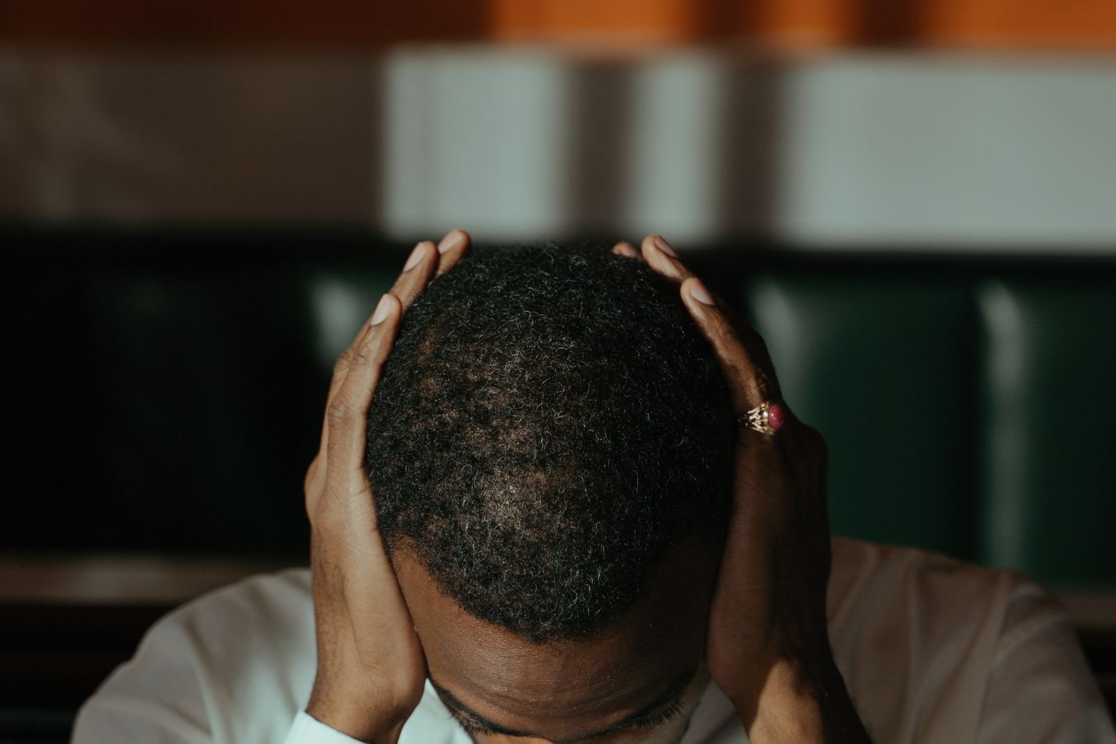 Man with his head in his hands at a desk