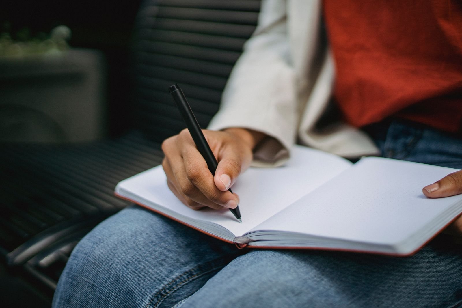 Man writing notes in a notebook outdoors