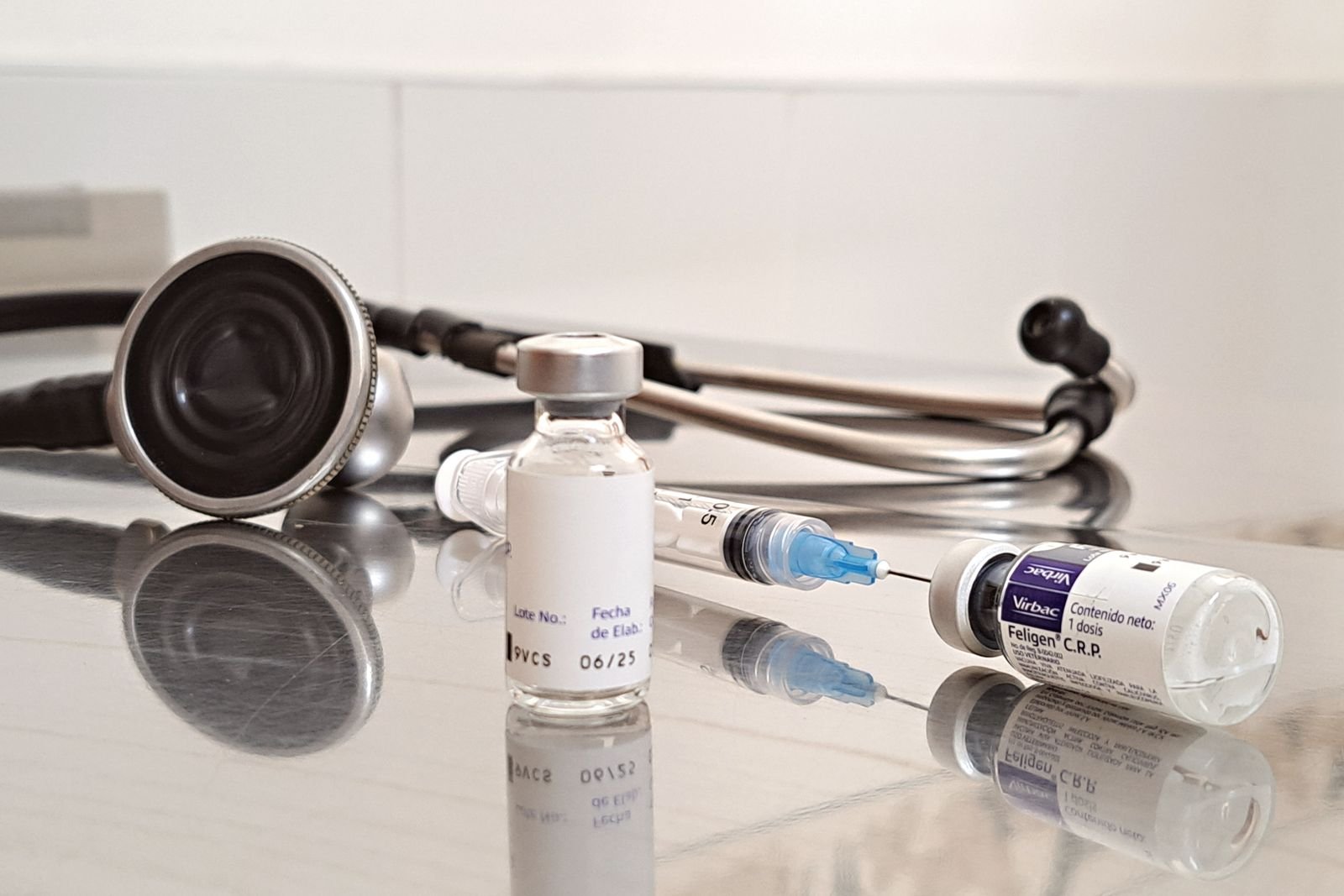 Medicine vials, a syringe and a stethoscope on a desk