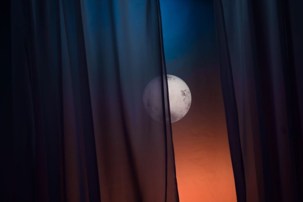 Moon seen through bedroom curtains at night
