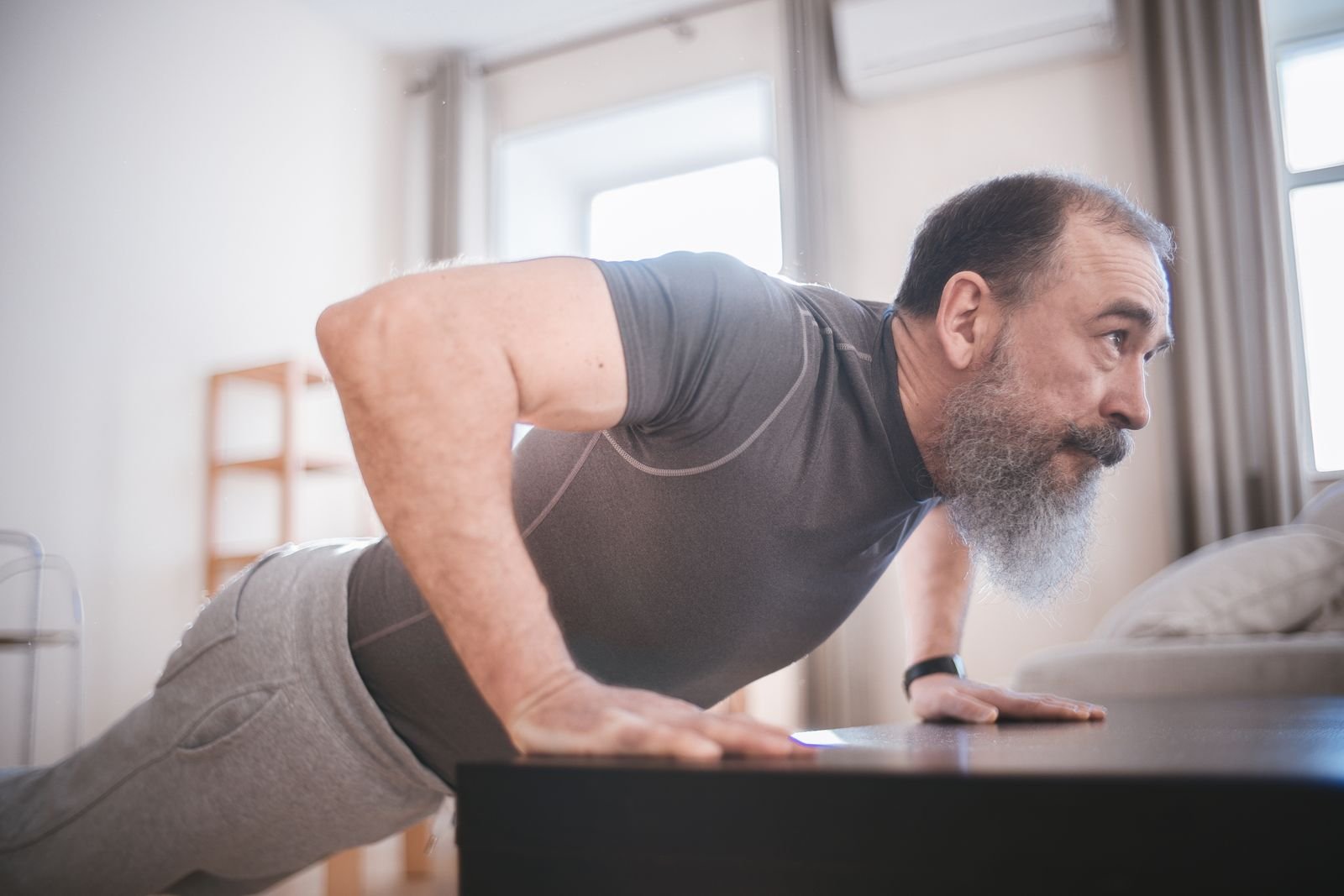 Older man doing push-ups in his living room