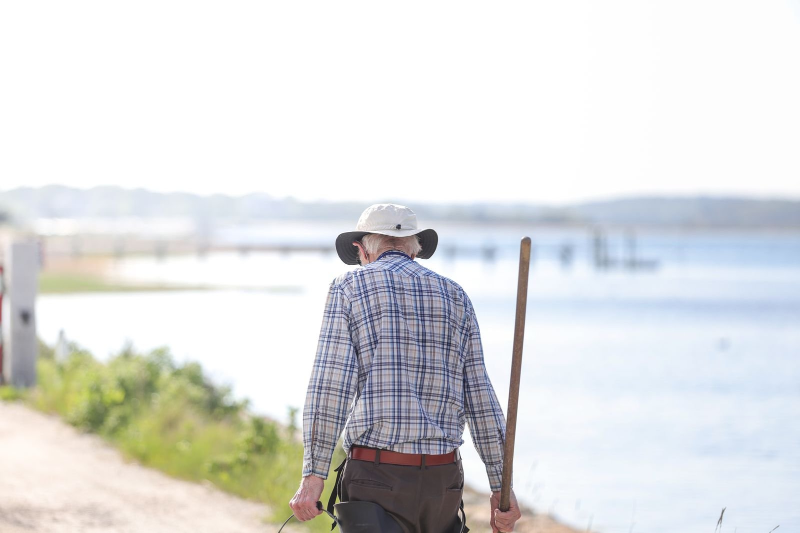 Older man walking outdoors with a stick