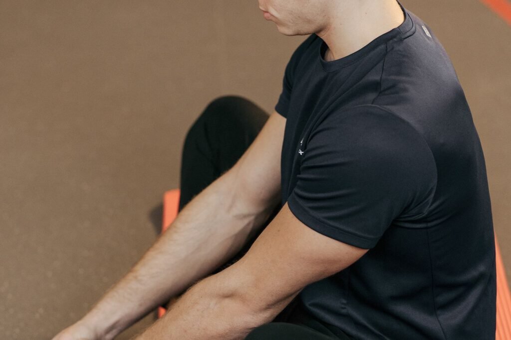 Man sitting and stretching on a yoga mat