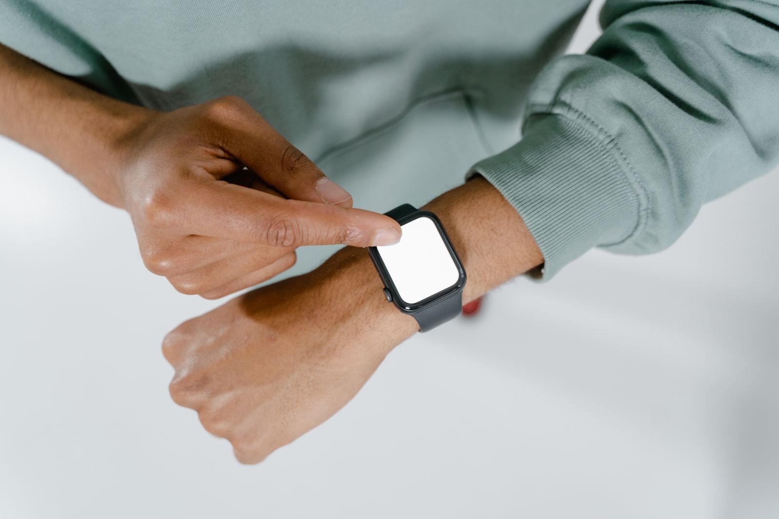 Person tapping a smartwatch on their wrist