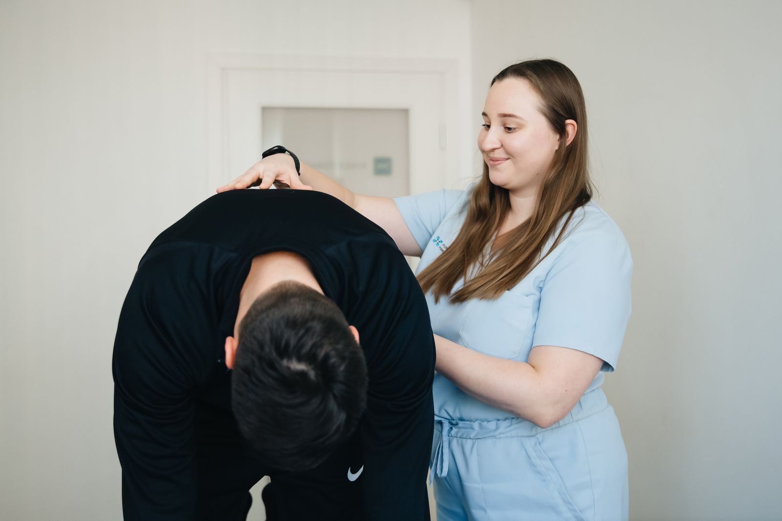 Physiotherapist guiding a man through a back exercise