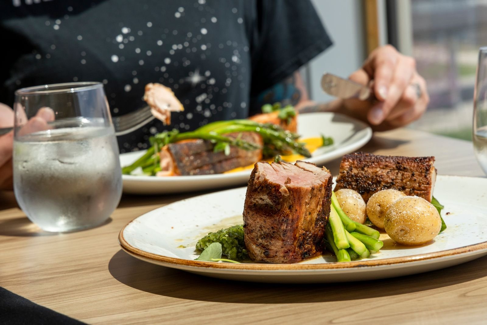 Plate of meat with vegetables and potatoes served outdoors