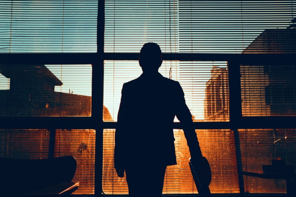 Silhouette of a man at an office window at dusk