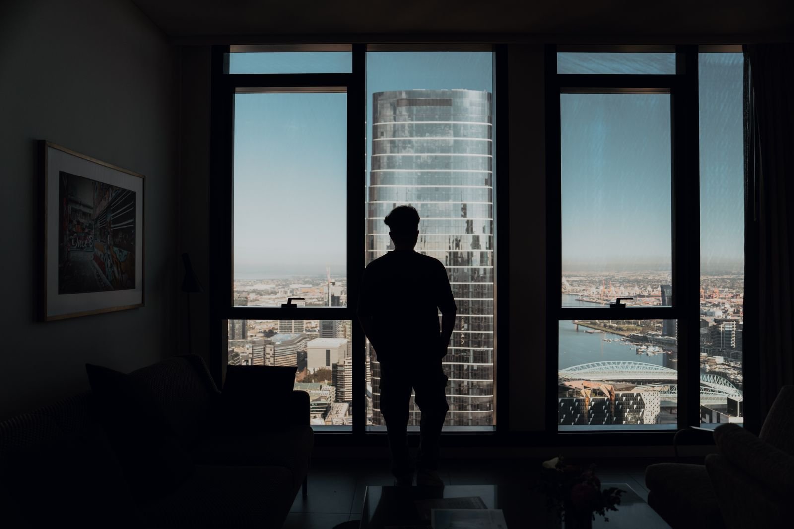 Silhouette of a man standing at a city window
