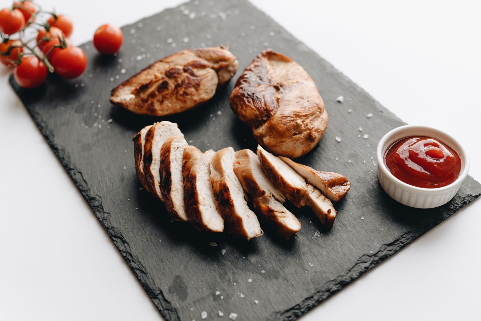 Sliced grilled chicken breast with cherry tomatoes
