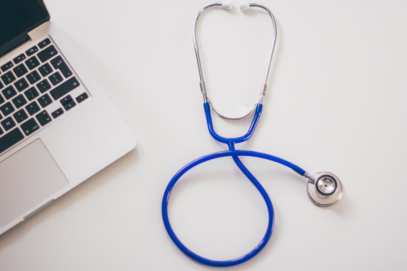 Stethoscope resting beside a laptop
