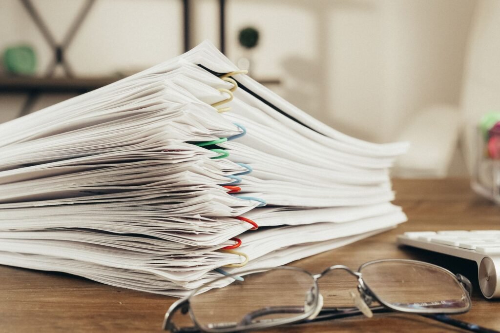 Tall stack of paperwork on a desk