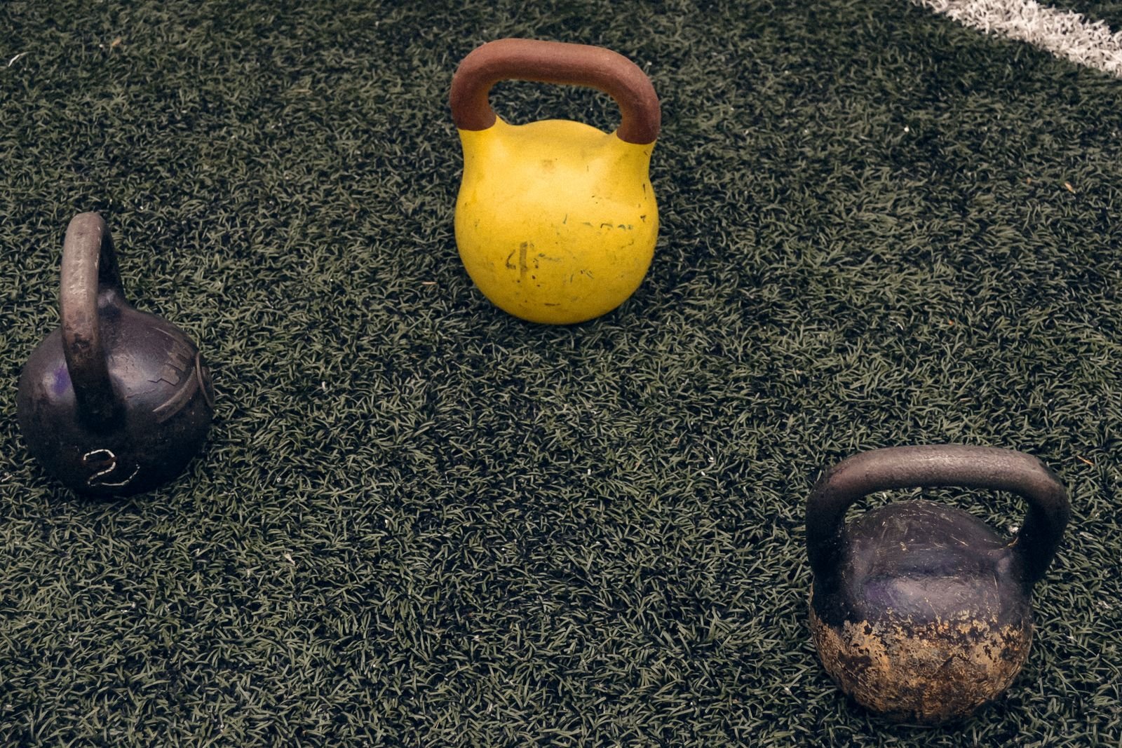 Three kettlebells on grass