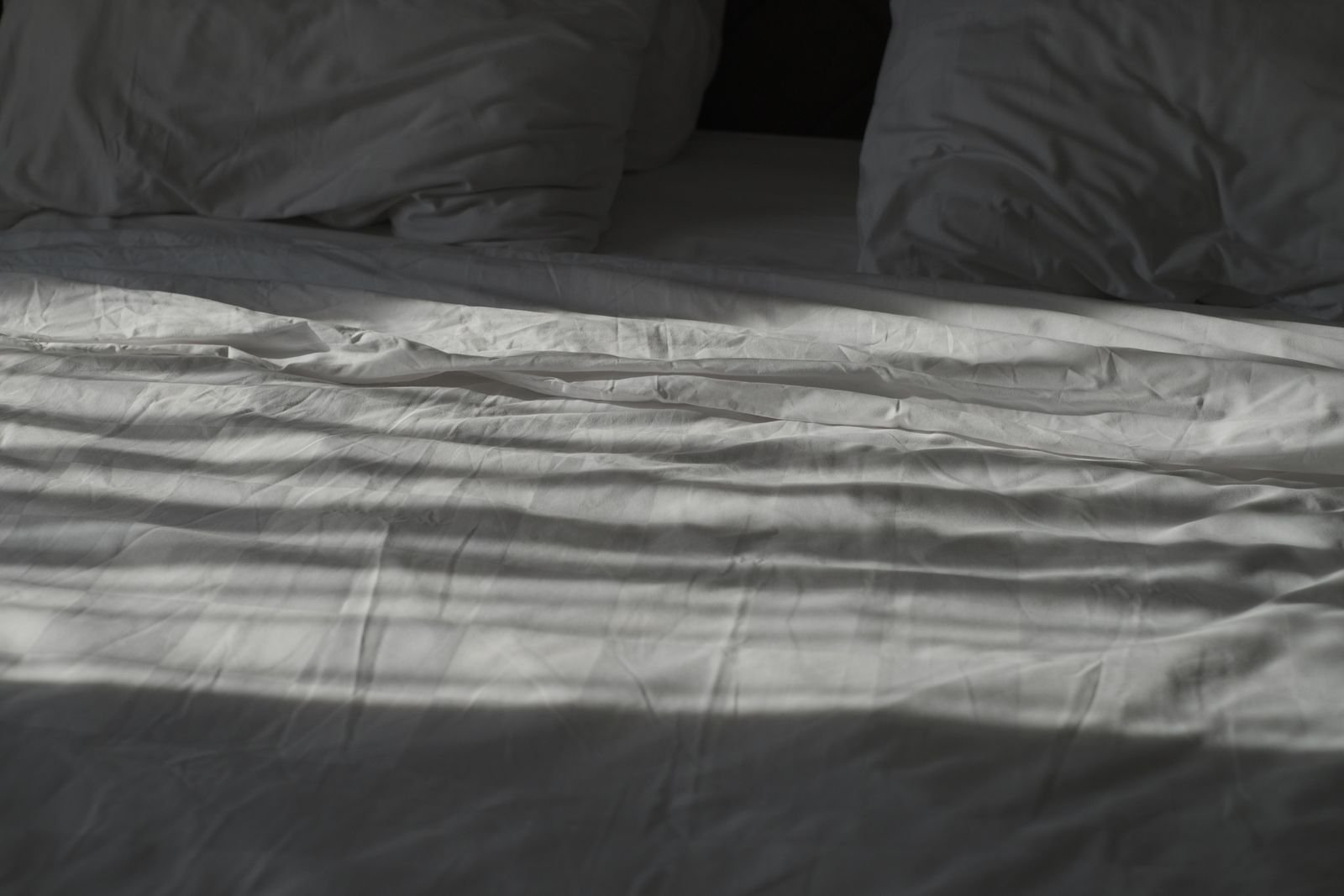 White bedding and pillows in soft shadow