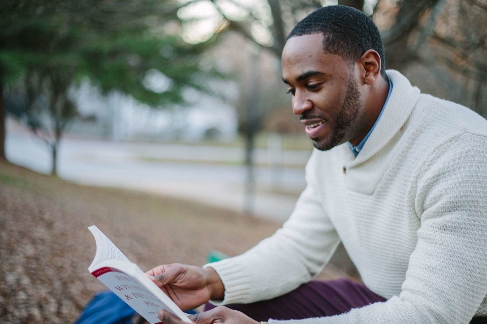 Young man reading a book in a park
