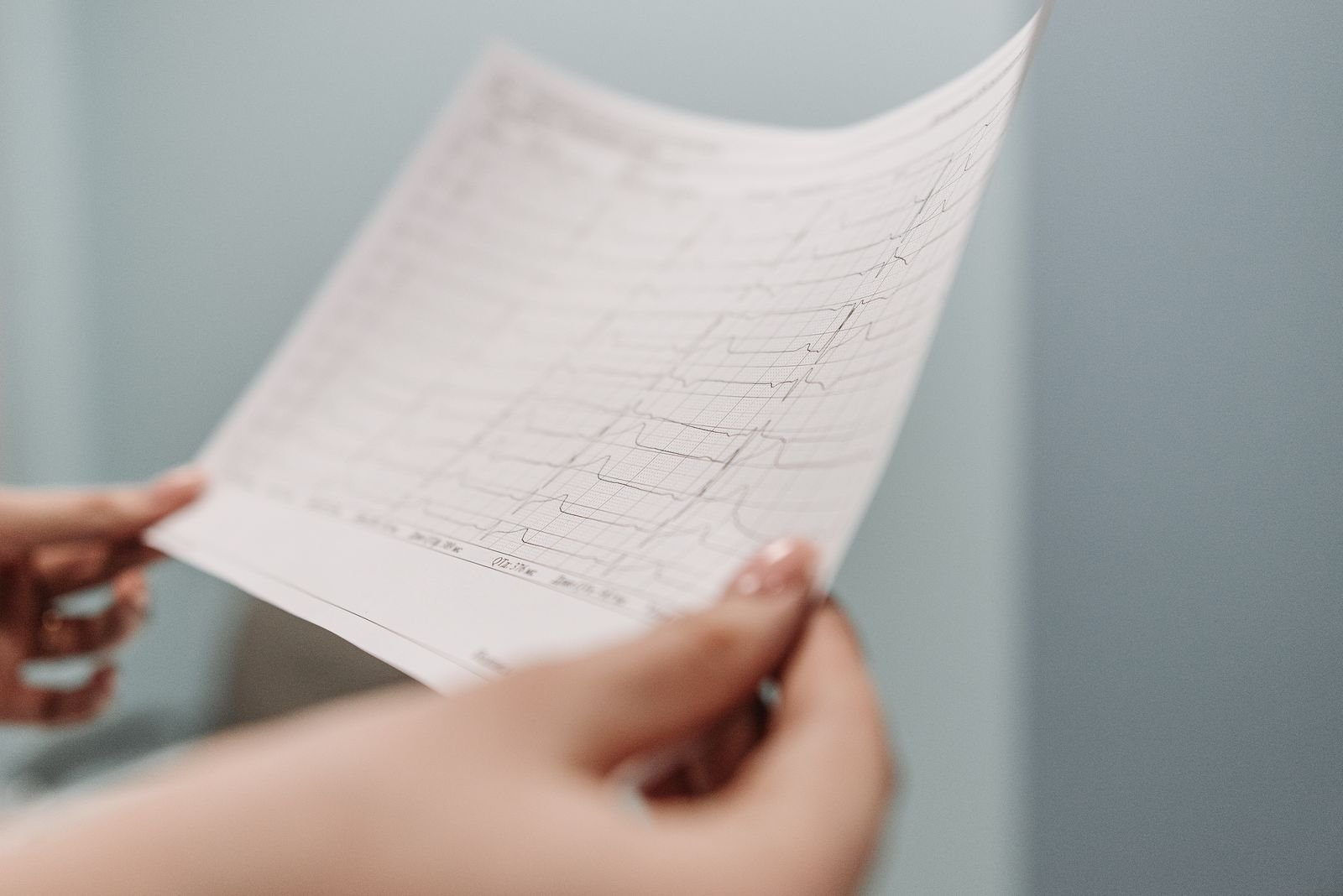 Hands holding a printed heart test result