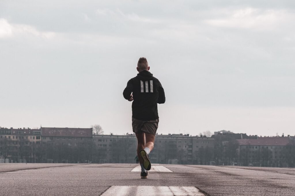 Man running on an open path, seen from behind