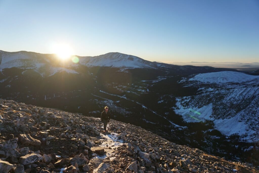 Walker on a rocky mountain ridge at sunrise